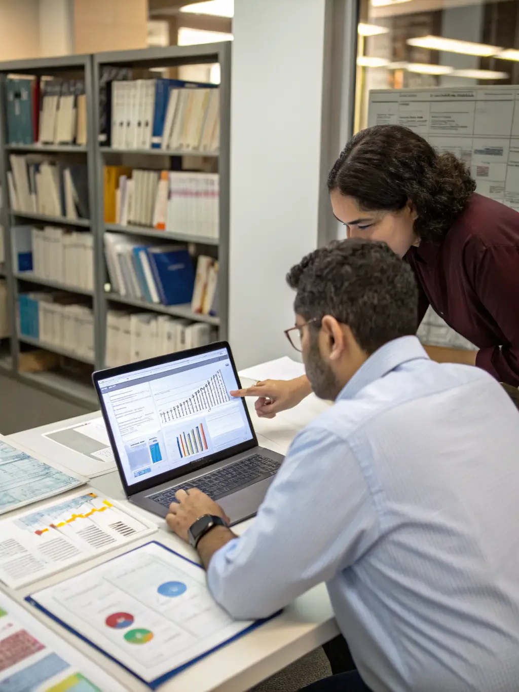 A picture of researchers examining digitized archival materials on computers in a modern, well-lit research room.